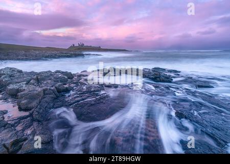 Tramonto al castello di Dunstanburgh Foto Stock