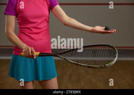 Vista ravvicinata sul giocatore di squash femminile che tiene racchetta e palla Foto Stock