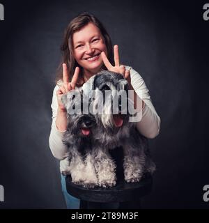 Ritratto in studio di una donna con due cani schnauzer in miniatura Foto Stock