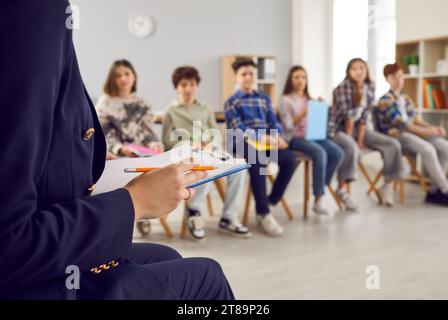 Foto ritagliata di un insegnante che parla con i bambini delle scuole in classe Foto Stock