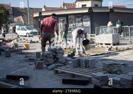 Belgrado, Serbia, 18 ottobre 2023: Operai edili che pavimentano l'altopiano intorno al mercato di Zemun Foto Stock