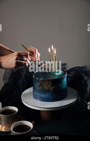 donna che taglia una torta deliziosa per una vacanza in un dolce di rami di abete rosso Foto Stock