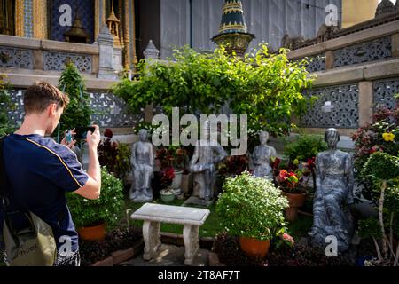 Thailandia. 19 novembre 2023. Un turista scatta una foto di statue in mostra al Grand Palace di Bangkok. Vita quotidiana a Bangkok, in Thailandia, mentre il governo thailandese spinge per la crescita del mercato turistico internazionale, ha recentemente messo in atto programmi di ingresso senza visto nel Regno per i turisti internazionali provenienti da Russia, Cina e India. Crediti: Matt Hunt/Neato/Alamy Live News Foto Stock