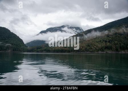 La lussureggiante foresta pluviale copre le calme acque dell'Inland Passage tra la costa orientale dell'Isola di Vancouver e la terraferma canadese. Foto Stock