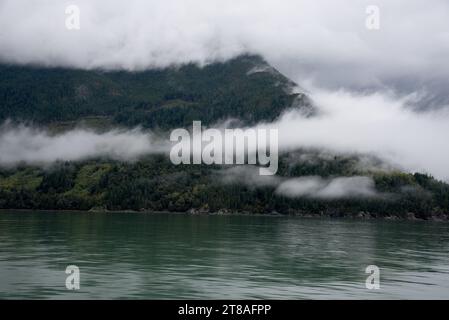 La lussureggiante foresta pluviale copre le calme acque dell'Inland Passage tra la costa orientale dell'Isola di Vancouver e la terraferma canadese. Foto Stock