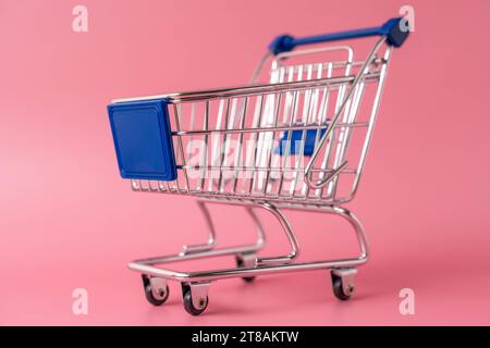 Augusta, Baviera, Germania - 15 novembre 2023: Carrello della spesa in miniatura di fronte a sfondo rosa *** Miniatur Einkaufswagen vor pinkem Hintergrund credito: Imago/Alamy Live News Foto Stock