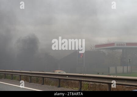 Feering, Colchester, Essex, Regno Unito. 19 novembre 2023. Un'auto incendiata vicino alla A12 Arterial Road vicino a Colchester, fuori da una fermata di sosta Greggs and Burger King, e vicino a una stazione di servizio esso. Il traffico viene rallentato durante il passaggio. Rapporto incidente: Causa dell'incendio: Surriscaldamento, causa sconosciuta. Fonte di accensione: Solo veicolo - motore, tubazione del carburante o pompa Foto Stock