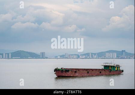 Una nave container commerciale, vuota, che saliva nel golfo del Tonchino, vicino a ha Long Bay, in Vietnam Foto Stock