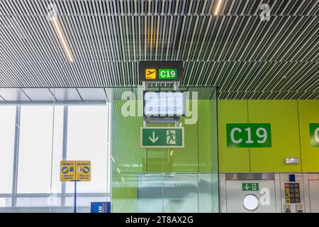 Vista del tabellone informativo e dei cartelli situati sopra uno dei cancelli d'imbarco dell'aeroporto, con i dettagli per i passeggeri sul loro volo. Gran Foto Stock