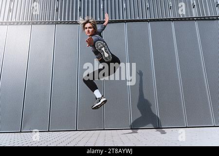 Atleta donna che salta come un combattente kung fu in strada Foto Stock