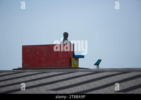 Scultura Nehalennia, donna seduta su una banca sul lungomare di domburg, scattata da dietro la scultura Foto Stock