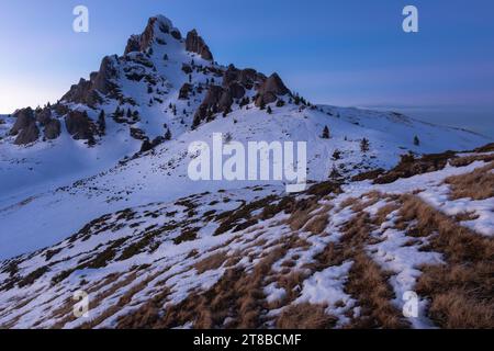 Vista panoramica della vetta del monte Ciucas al tramonto in inverno, Carpazi, Romania Foto Stock