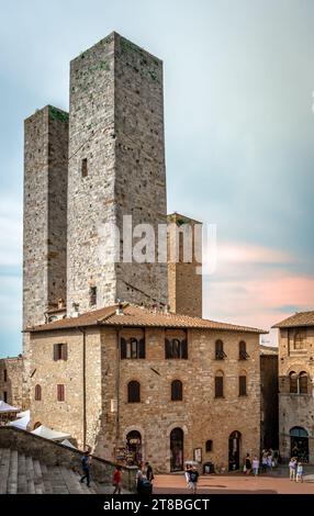 Una torre che si affaccia su Piazza del Duomo a San Gimignano, Toscana, Italia. Foto Stock