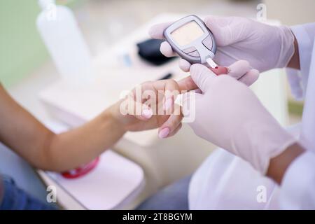 Controllo medico livello di zucchero nel sangue del paziente in ospedale Foto Stock