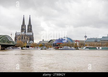 Rhein Hochwasser in Köln beim Pegel von 693 cm aus Sicht des Deutzer Rheinufers auf die Innenstadt von Köln. mit Kölner Dom, Musical Dome und Hohenzollernbrücke. Warnschilder in deutscher und englischer Sprache wurden aufgestellt und erste Abschnitte abgesperrt. Es wird derzeit mit einem steigenden Pegel von über 7 Metern gerechnet. 19.11.2023 Köln Deutz NRW Deutschland *** le inondazioni del Reno a Colonia ad un livello di 693 cm dalla riva Deutz del Reno come visto dal centro della città di Colonia con la cattedrale di Colonia, la cupola musicale e il ponte Hohenzollern sono stati messi cartelli di avvertimento in tedesco e inglese Foto Stock