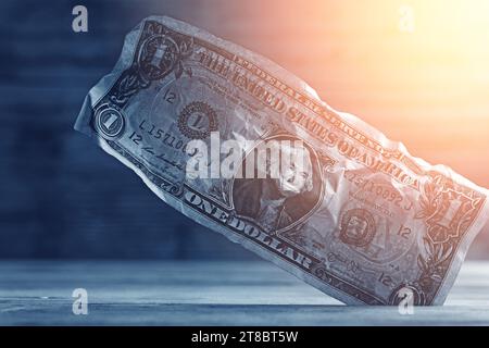 Primo piano di una banconota da un dollaro schiacciata bloccata in un vuoto nel pavimento. Foto Stock