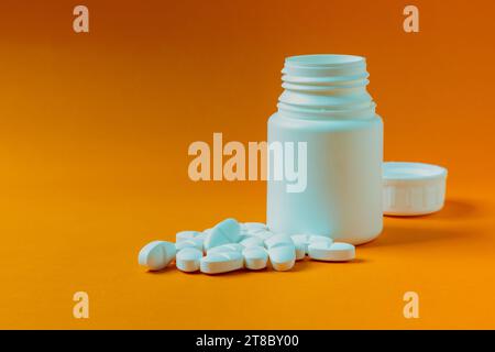 contenitore per pillole di colore arancione e bianco e stetoscopio su  sfondo colorato Foto stock - Alamy