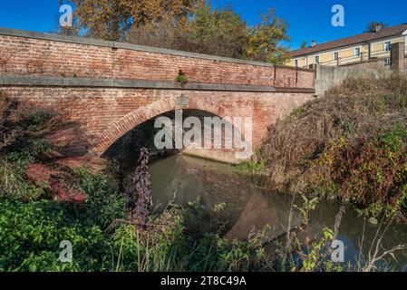Antico ponte ad arco in mattoni, costruito nel 1839, sul canale nella campagna della Pianura Padana a Borgo Cornalese di Villastellone, Torino, Italia Foto Stock