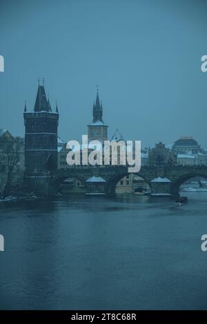 Paesaggio invernale a Praga, Repubblica Ceca, con il fiume Moldava e Karlov Most in serata. Foto Stock