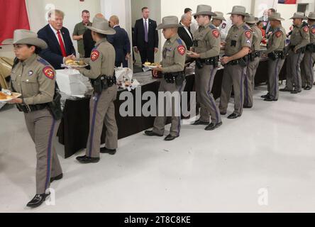 Edinburg, Texas USA, 19 novembre 2023:.l'ex presidente DONALD TRUMP stringe la mano alle truppe del Dipartimento di pubblica sicurezza del Texas mentre ritirano la cena di tacchino all'aeroporto internazionale del Texas meridionale. Trump è volato per una rapida apparizione in campagna elettorale.. Foto della piscina di Delcia Lopez Foto Stock