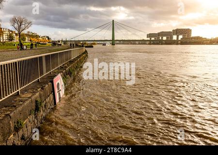 Rhein Hochwasser in Köln beim Pegel von 693 cm aus Sicht des Deutzer Rheinufers Höhe der Deutzer Brücke. mit Blick auf den Rheinauhafen mit ihren markanten Kranbauten bei Sonnenuntergang. 19.11.2023 Köln Deutz NRW Deutschland *** alluvione del Reno a Colonia ad un livello dell'acqua di 693 cm dalla riva Deutz del Reno all'altezza del ponte Deutz con vista sul Rheinauhafen con i suoi edifici di gru al tramonto 19 11 2023 Colonia Deutz NRW Germania credito: Imago/Alamy Live News Foto Stock