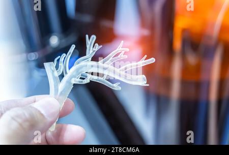 mano con un oggetto a forma di vaso sanguigno umano medicalmente accurato stampato su stampante 3d. Foto Stock