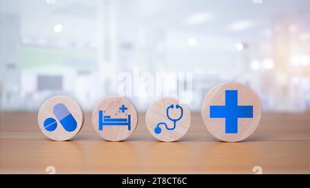 Blocchi di legno con simboli medici su fondo di legno che rappresentano il concetto di salute con il trattamento e la medicina. Foto Stock