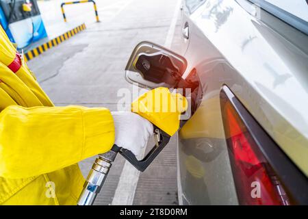 uomo che pompava benzina in auto al distributore di benzina. Foto Stock