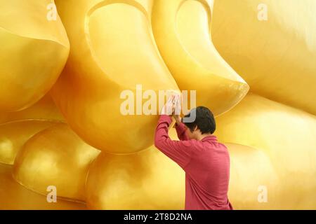 Uomo di toccare il dito del Grande Buddha immagine per la benedizione, Wat Muang tempio, Ang Thong Provincia, Thailandia Foto Stock