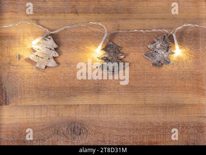 Forma albero di Natale chiaro a natale su sfondo di legno Foto Stock