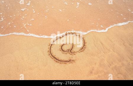 Simbolo di posta elettronica disegnare sulla spiaggia Foto Stock