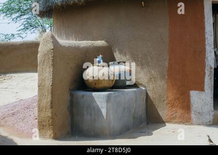 Vasi d'acqua tenuti fuori da una casa di fango nel deserto del Thar, nel Rajasthan, in India Foto Stock