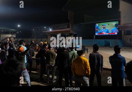 Guwahati, Assam, India. 19 novembre 2023. I tifosi di cricket in un campo guardano la finale di un giorno internazionale (ODI) della Coppa del mondo di cricket maschile ICC 2023 tra India e Australia, su uno schermo proiettore, il 19 novembre 2023 a Guwahati, Assam, India. L'Australia ha sconfitto l'India con 6 wickets 42 palline rimaste. Credito: David Talukdar/Alamy Live News credito: David Talukdar/Alamy Live News Foto Stock