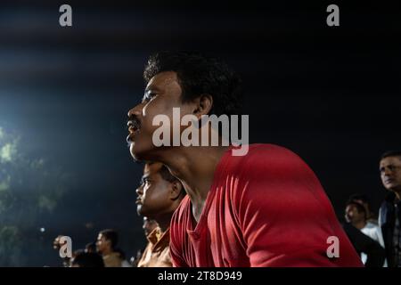 Guwahati, Assam, India. 19 novembre 2023. I tifosi di cricket in un campo guardano la finale di un giorno internazionale (ODI) della Coppa del mondo di cricket maschile ICC 2023 tra India e Australia, su uno schermo proiettore, il 19 novembre 2023 a Guwahati, Assam, India. L'Australia ha sconfitto l'India con 6 wickets 42 palline rimaste. Credito: David Talukdar/Alamy Live News credito: David Talukdar/Alamy Live News Foto Stock