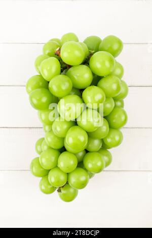 Uva Muscat fresca e lucida su sfondo di legno bianco. Foto Stock