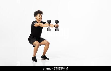 atleta che esegue squat con pesi manubri su sfondo bianco Foto Stock