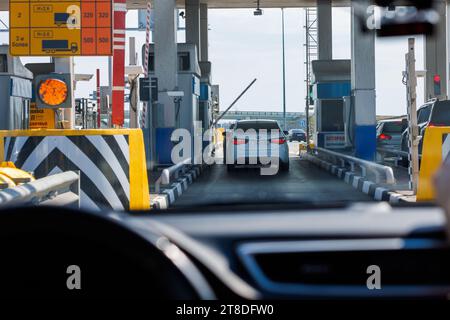 auto bianca che passa davanti al posto di controllo della strada a pedaggio, vista dall'interno dell'auto Foto Stock