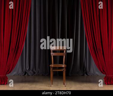 Sedia in legno d'epoca sul palco dello spettacolo. Sedia su palco vuoto con tende rosse Foto Stock