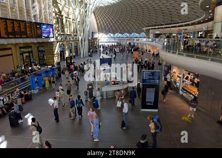 Persone nell'atrio principale in attesa dei treni alla stazione ferroviaria di Kings Cross, Londra agosto 2023 Foto Stock