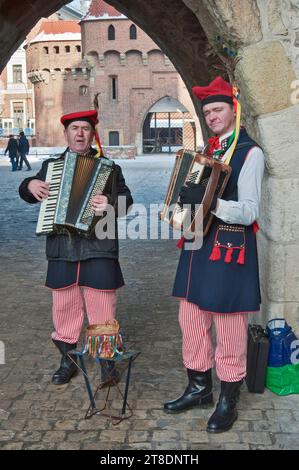 I musicisti di strada nella regione di Cracovia indossano costumi alla porta Florianska a Cracovia, Polonia Foto Stock