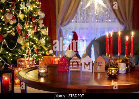 Decorazioni dell'albero di Natale nel soggiorno di notte. Interni natalizi con ghirlande di candele, regali sotto l'albero di Natale, tutto è pronto per Natale. Foto Stock