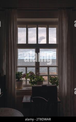 Vista dalla finestra al mare e al cielo attraverso le tende Foto Stock