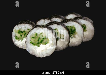 sushi roll con cetriolo isolato su sfondo nero. Foto Stock