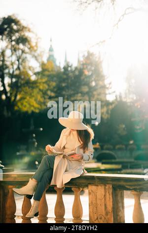 Donna che legge un libro in un parco con il Castello di Praga sullo sfondo Foto Stock