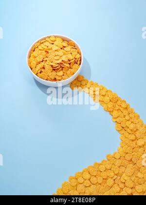 fiocchi di mais in un recipiente su sfondo blu Foto Stock