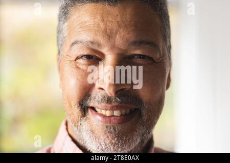 Ritratto di un uomo birazziale anziano felice che indossa una camicia a scacchi a casa Foto Stock