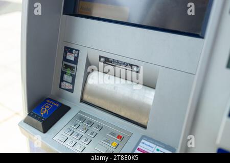Bancomat automatico argento appeso a una parete di cemento grigia Foto Stock