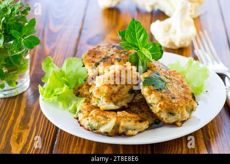 cotolette di cavolfiore fritte vegetariane, in un piatto su un tavolo di legno. Foto Stock