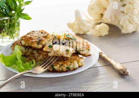 cotolette di cavolfiore fritte vegetariane, in un piatto su un tavolo di legno. Foto Stock