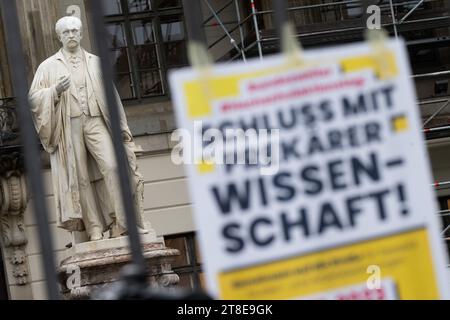 Berlino, Germania. 20 novembre 2023. Davanti alla statua di Hermann von Helmholtz di fronte all'Humboldt-Universität zu Berlin è appeso un cartello con la scritta "niente più scienza precaria" durante un attacco di avvertimento alle università di Berlino. Nella disputa salariale del settore pubblico, i sindacati Verdi e Gewerkschaft Erziehung und Wissenschaft hanno chiesto un giorno di sciopero universitario. Credito: Sebastian Christoph Gollnow/dpa/Alamy Live News Foto Stock